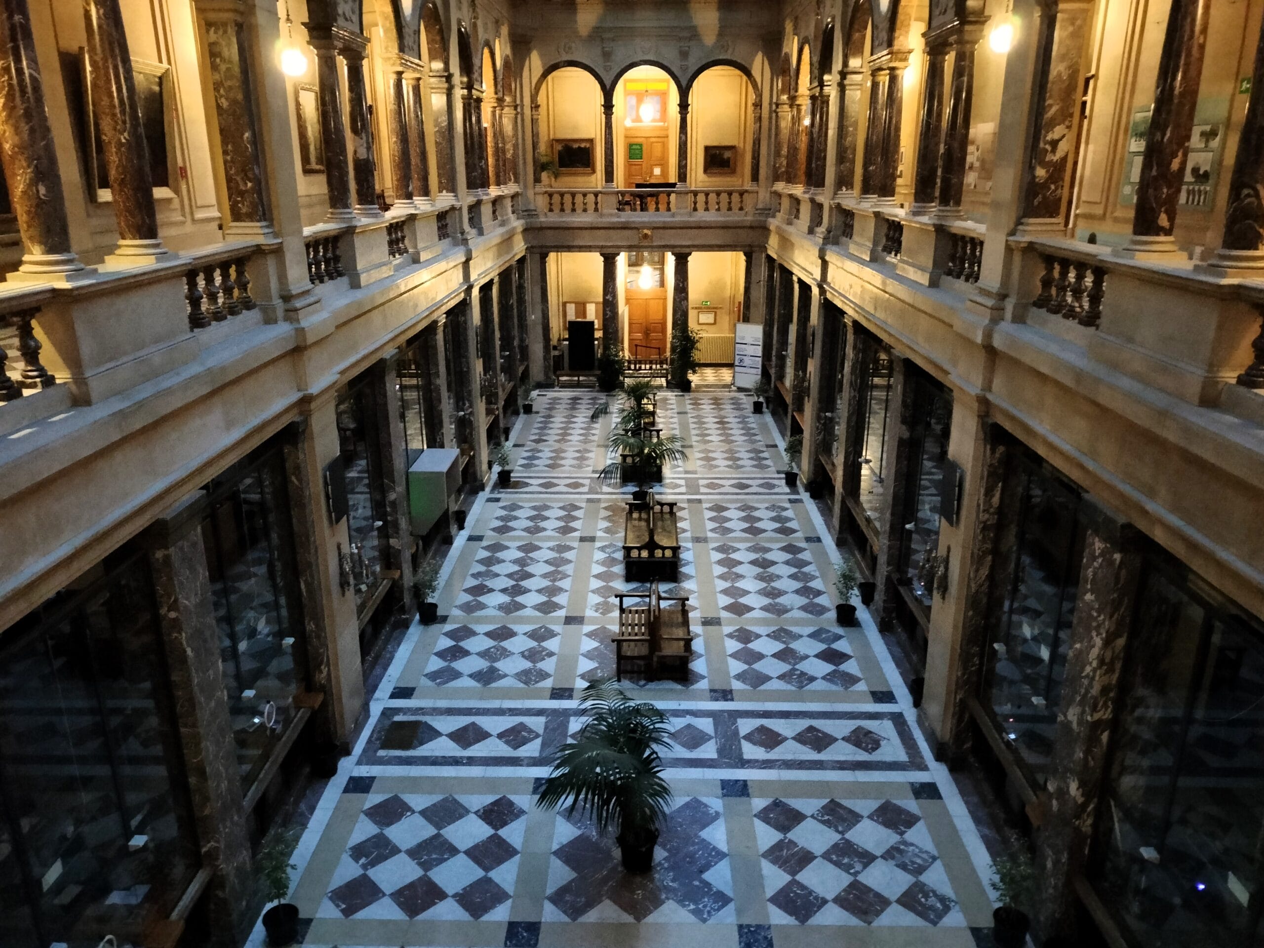 La salle des guichets de l’Hôtel de ville à Schaerbeek. Des visites guidées sont organisées par la commune en français et permettent aux enseignants de parcourir le bâtiment avec leurs élèves. Une façon de combiner plusieurs éléments de ce dossier pédagogique : visite de la place Colignon sur laquelle Roger Nols a déambulé à dos de chameau le 31 décembre 1986 ; salle des guichets permettant de parler de l'"affaire des guichets" ; puis visite du hall des bourgmestres pour aller voir le buste retourné de l'ancien bourgmestre Roger Nols. Pour planifier cette visite, contactez Anne-Cécile Maréchal : acmarechal@1030.be 